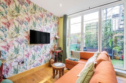 a living room with a couch and a tv on a wall at Charming 2 Bed and 3 Bath Apartment in Covent Garden ZONE 1 in London