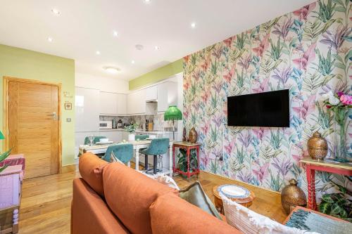 a living room with a couch and a tv on a wall at Charming 2 Bed and 3 Bath Apartment in Covent Garden ZONE 1 in London