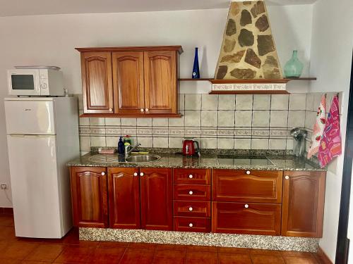 una cucina con mobili in legno e un frigorifero bianco di Lupita's House a Punta de Mujeres