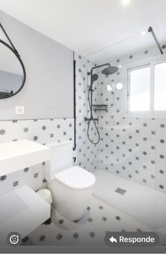 a bathroom with a toilet and a sink and a shower at La Flor del Azafrán in Lécera