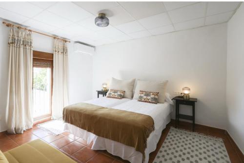 une chambre avec un lit et une grande fenêtre dans l'établissement La Flor del Azafrán, à Lécera