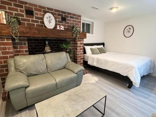 Un dormitorio con un sofá y una cama y una pared de ladrillos. en Modern Newly-Renovated Suite Free Parking pet friendly, en Toronto