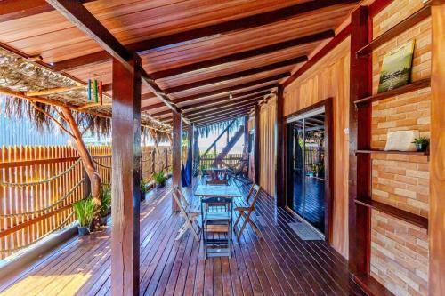 un portico con tavolo e sedie di Pé na areia Brava 50m do mar Churras Ar Condincionado a Itajaí