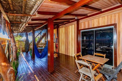 una sala da pranzo con tavolo e sedie su un portico di Pé na areia Brava 50m do mar Churras Ar Condincionado a Itajaí