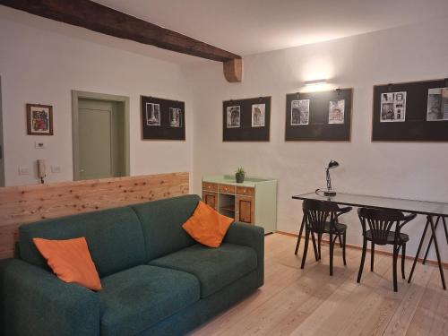 a living room with a green couch and a table at Vicolo al Duomo in Trento