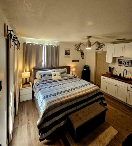 a bedroom with a large bed and a kitchen at 10 Minutes from Universal - Relaxing Guest Suite in Orlando