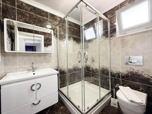 un bagno con doccia, lavandino e WC di Villa Fergana a Ovacik