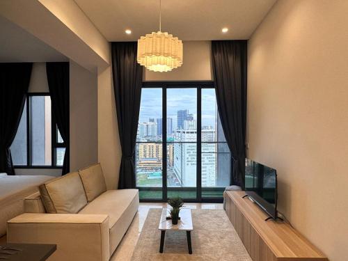 Lucentia Residences Kuala Lumpur By Luxury Suites BBCC في كوالالمبور: غرفة معيشة مع أريكة ونافذة كبيرة