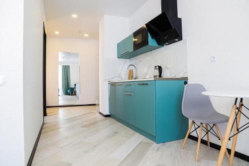 cocina con armario azul y mesa en Hotel Qumli Apartment with mountain views, en Kʼumlistsʼikhe