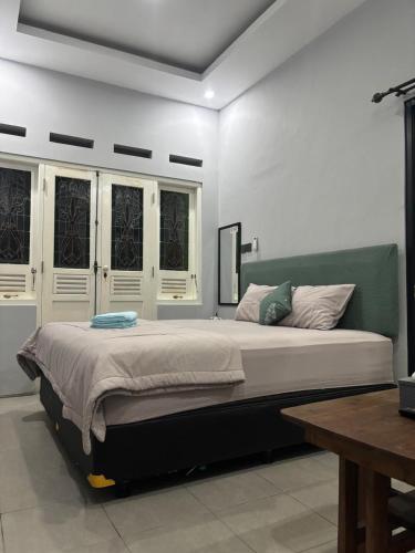 a bedroom with a large bed with white walls at Omah Saha at Kraton in Yogyakarta