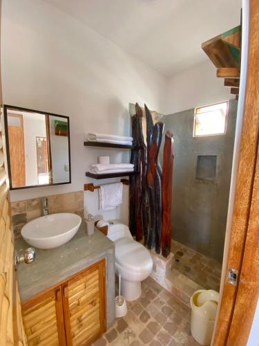 a bathroom with a toilet and a sink at Casa Kahuna in Canoas de Punta Sal