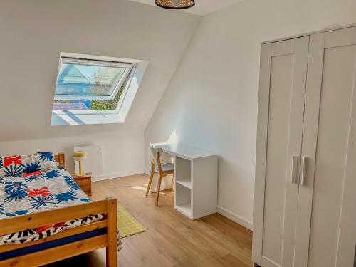 a bedroom with a bed and a desk and a window at Maison le 21B au coeur de Lesconil in Plobannalec-Lesconil