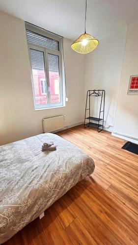 a bedroom with a bed and a wooden floor at Maison partagée 4 chambres Saint Roch Roubaix in Roubaix