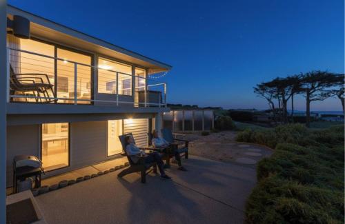eine Person, die auf der Veranda eines Hauses sitzt in der Unterkunft Coastal Tee Lodge by Sonoma Stays - Ocean Views in Bodega Bay