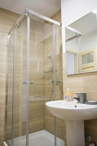 a bathroom with a glass shower and a sink at Szent Ferenc Vendégház in Deva