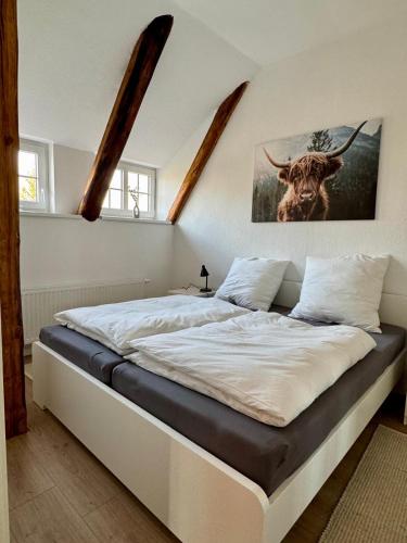 a bed in a bedroom with a picture of a bull at Robbe beim Ochsenturm am Deich 