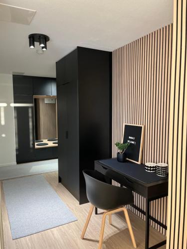 una scrivania nera con sedia nera in una stanza di Keisari Apartment a Rovaniemi