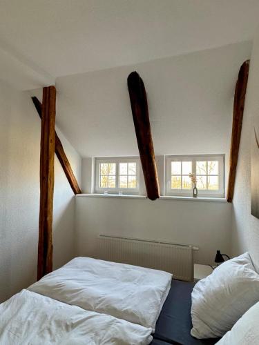 two beds in a room with two windows at Robbe beim Ochsenturm am Deich in Dingen