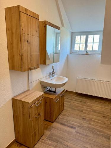 a bathroom with a sink and wooden cabinets at Robbe beim Ochsenturm am Deich in Dingen