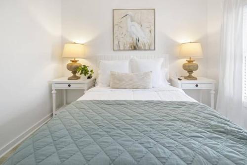 a white bedroom with a large bed with two lamps at Weekend Escape on the Coast-Relax & Unwind in Pass Christian