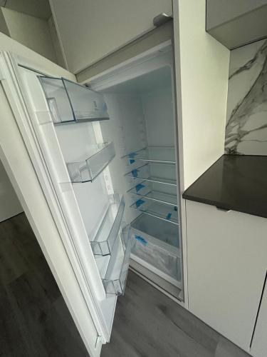 an empty refrigerator with its door open in a kitchen at Sea and lake KinKas in Mielno