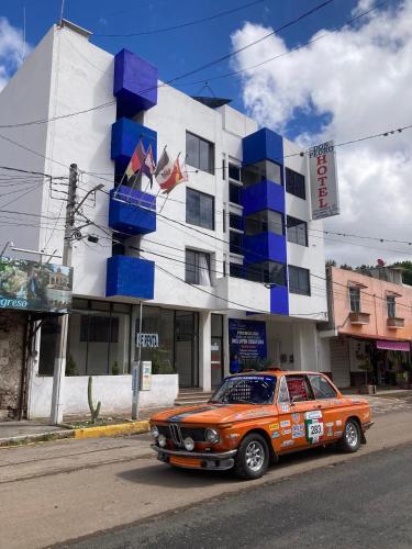 an orange car parked in front of a building at Hotel Don Pedro Centro in Villa de Tamazulapan