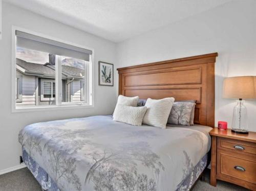 a bedroom with a large bed and a window at Rockies 3BR Townhome w Stunning Views Near DT in Canmore
