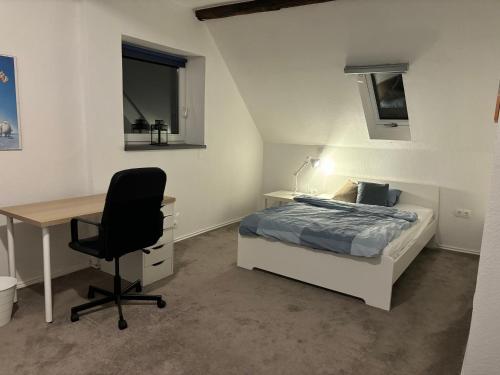 um quarto com uma cama, uma escrivaninha e uma cadeira em Landblick em Ovelgönne