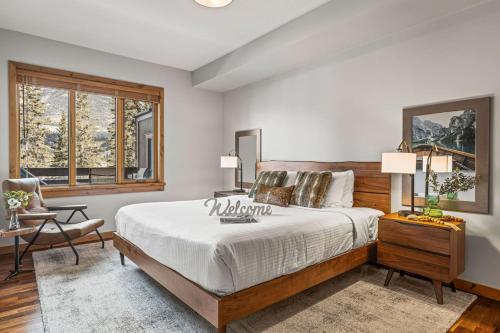 a bedroom with a bed and a desk and a window at 2BR Modern Luxe Condo with Hot Tub and Views in Canmore