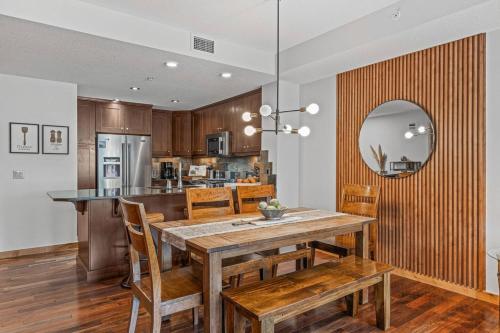 a kitchen and dining room with a wooden table and chairs at 2BR Modern Luxe Condo with Hot Tub and Views in Canmore