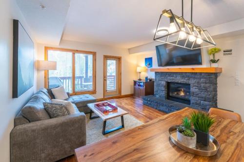 Serene 3BR Rockies Stay with Hot Tub and Near DT في كانمور: غرفة معيشة مع أريكة ومدفأة