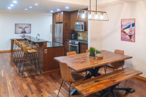 Serene 3BR Rockies Stay with Hot Tub and Near DT في كانمور: مطبخ وغرفة طعام مع طاولة وكراسي خشبية