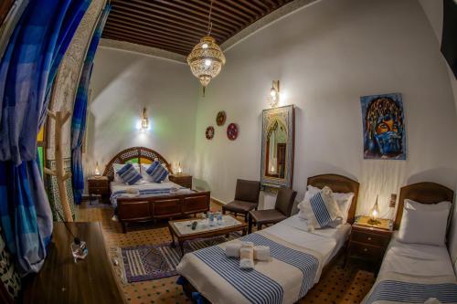 a hotel room with two beds and a living room at Riad Dar Bahja - More Than a Stay in Fès