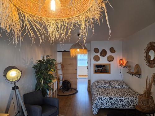 une chambre avec un lit et un plafond recouvert de paille dans l'établissement Studio plein sud le ciel le soleil et la mer, à Palavas-les-Flots