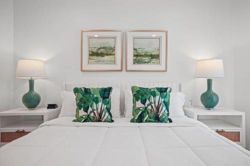 a bedroom with a white bed with two lamps at Mississippi Gulf Coast Basecamp-Central Location in Pass Christian
