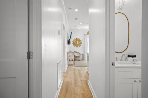 a white hallway with a sink and a mirror at Extended Stay Friendly-Full Kitchen & Laundry in Pass Christian