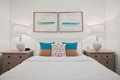a bedroom with a white bed with two lamps at Beach Access Condo-Walk to Downtown-Pets Welcome w/ Fee in Pass Christian
