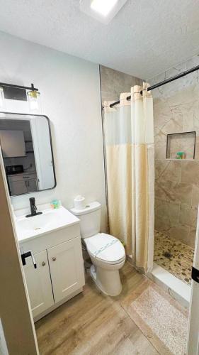 a bathroom with a toilet and a sink and a shower at Waterfront home with Firepit and Foosball Table in Fruitland Park