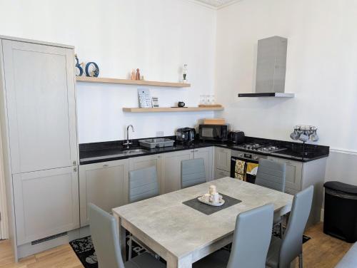 a kitchen with a table and a kitchen with a stove at 2 Bedroom House with Garden and Free Parking -10 min to London Bridge and near Lewisham Hospital in Lewisham