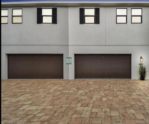 een huis met twee garagedeuren en een stenen oprit bij Downtown Sarasota 4 Unit Compound- Beach Shopping Park in Sarasota