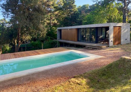 ein kleines Haus mit einem Swimmingpool davor in der Unterkunft Terrazas del Bosque in La Pedrera