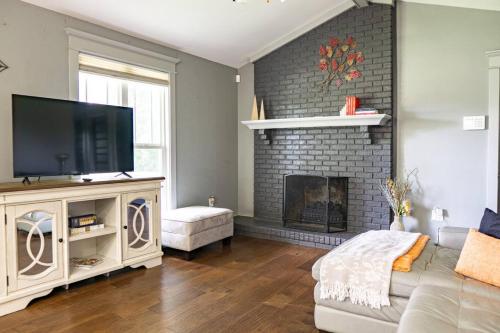 un soggiorno con camino e TV a schermo piatto di 3BR Country Retreat with Pool, Gazebo and Play a Crestview