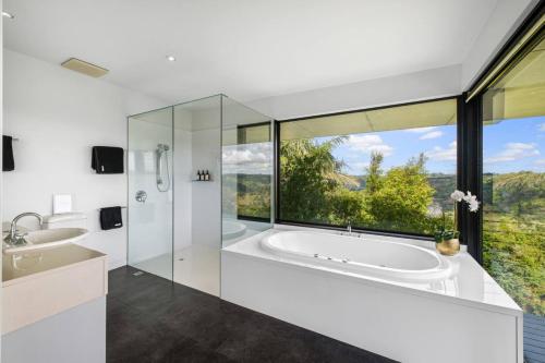 a bathroom with a tub and a large window at Magical Malindi, Montville. QLD in Montville