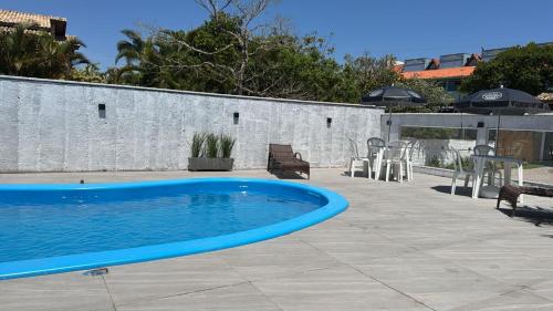 - une piscine bleue sur une terrasse avec une table et des chaises dans l'établissement Pousada Kauai, à Imbituba