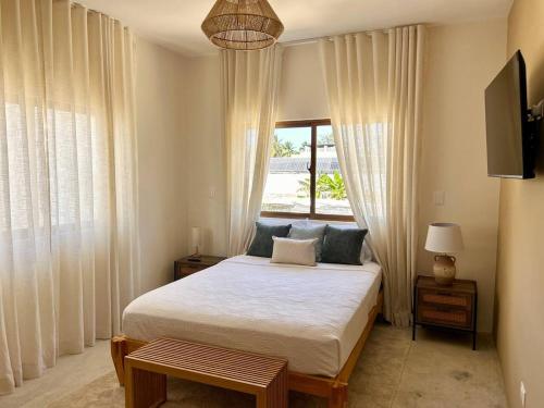 a bedroom with a large bed and a window at Villa Palmera in Las Terrenas