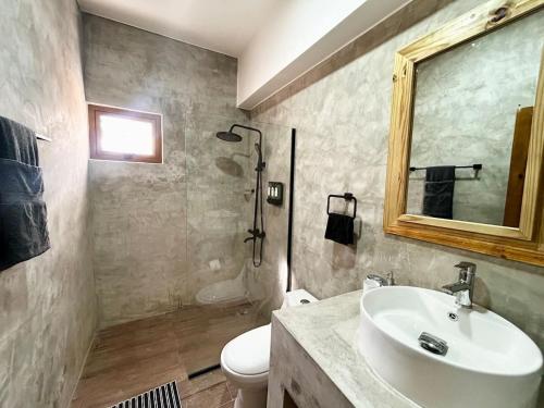 a bathroom with a sink and a toilet and a mirror at Villa Palmera in Las Terrenas