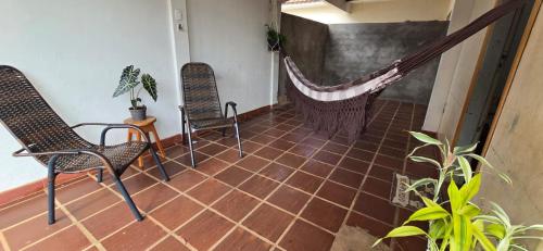 マリンガにあるDoce larの椅子2脚と床にハンモックが置かれた部屋