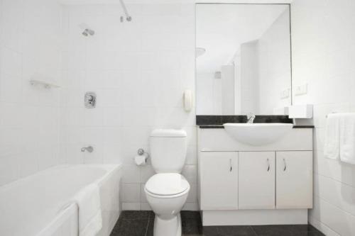 Opulent one bedroom apartment in parramatta. في سيدني: حمام أبيض مع مرحاض ومغسلة