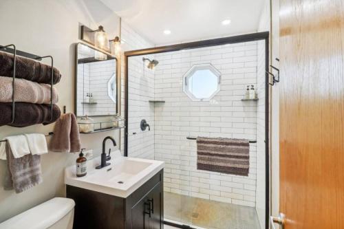 ein Badezimmer mit Waschbecken und Dusche in der Unterkunft Center Lake Cape Cod Escape Family Waterfront Home with Dock Scenic Views and Pet Friendly in Salem