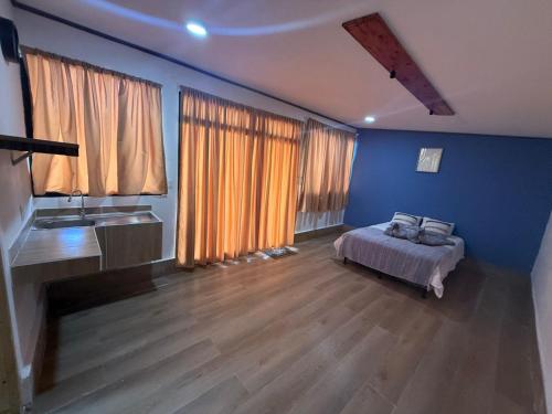 a bedroom with blue walls and a bed in a room at Green haven Poas in Poasito